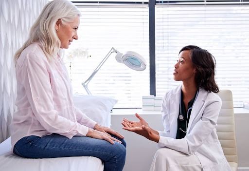 Mature woman discussing menopause symptom relief options with a female doctor during an office consultation.