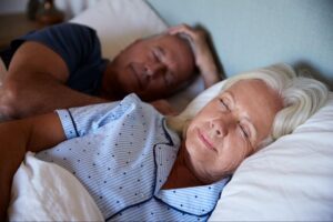 Midlife woman in bed during menopause, representing sleep disturbances and night waking.